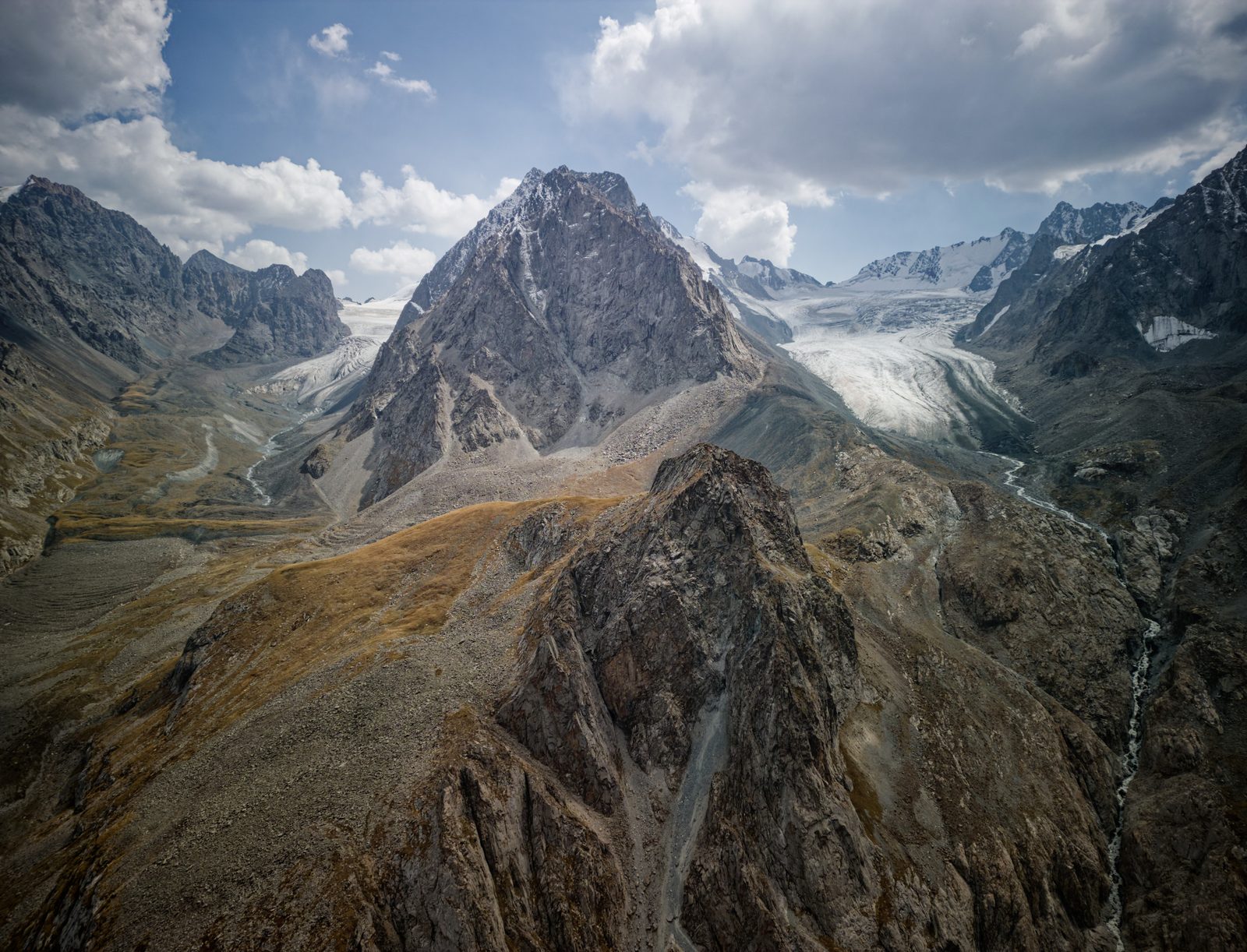 A rocky peak between two glaciers in a high mountain valley, seen from above